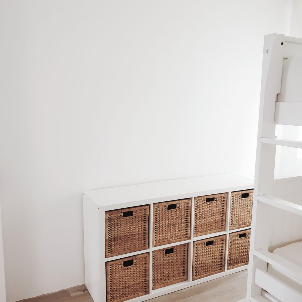 before picture of empty space above white bookshelf with rattan inserts
