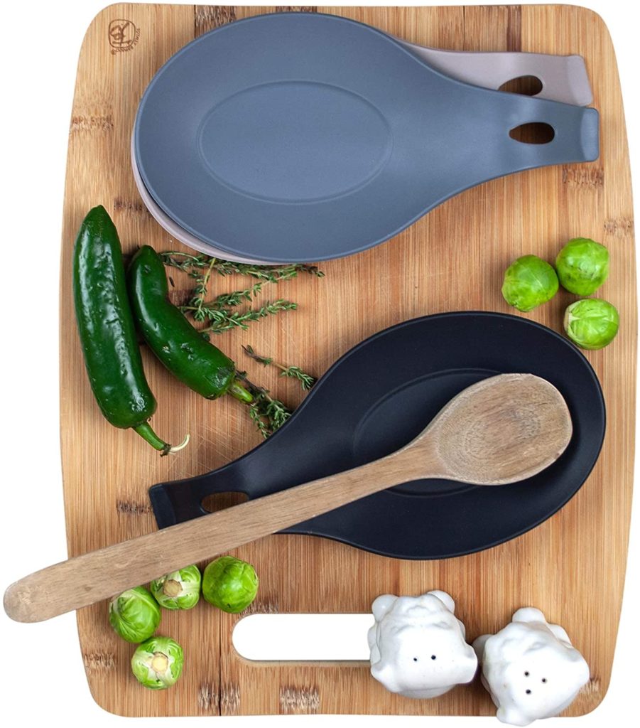 black and grey 3 piece set of silicone spoon rests on a wooden cutting board