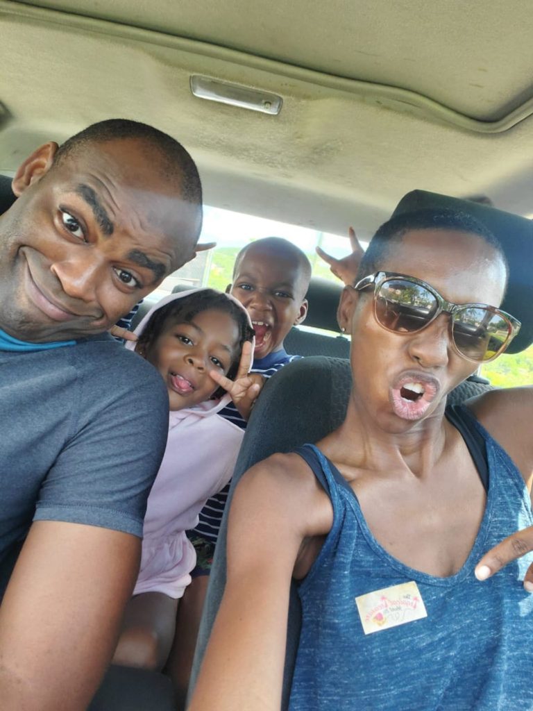 black family in car taking a silly selfie